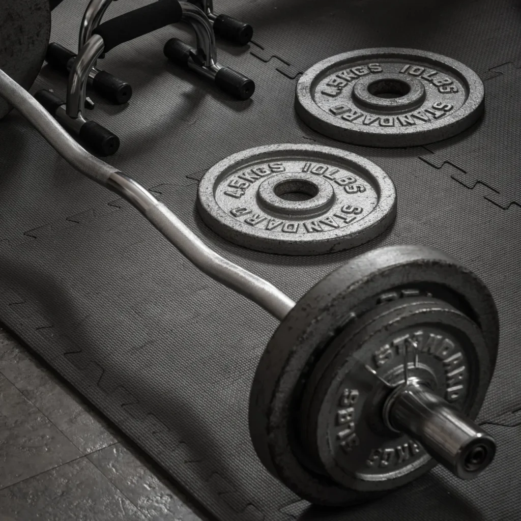 A loaded barbell with weight plates on gym floor.