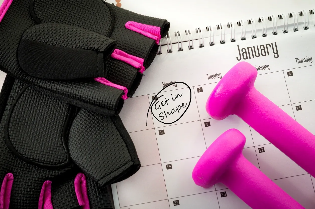 Workout gloves and dumbbells beside a calendar marked 'Get in Shape'.