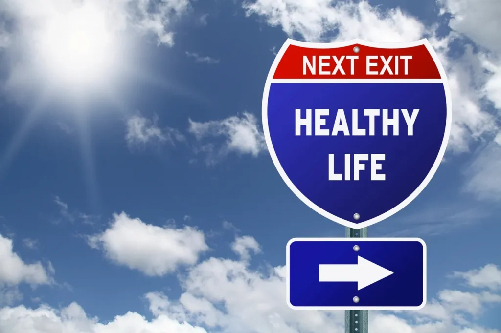 Road sign pointing to a healthy life with blue sky background.