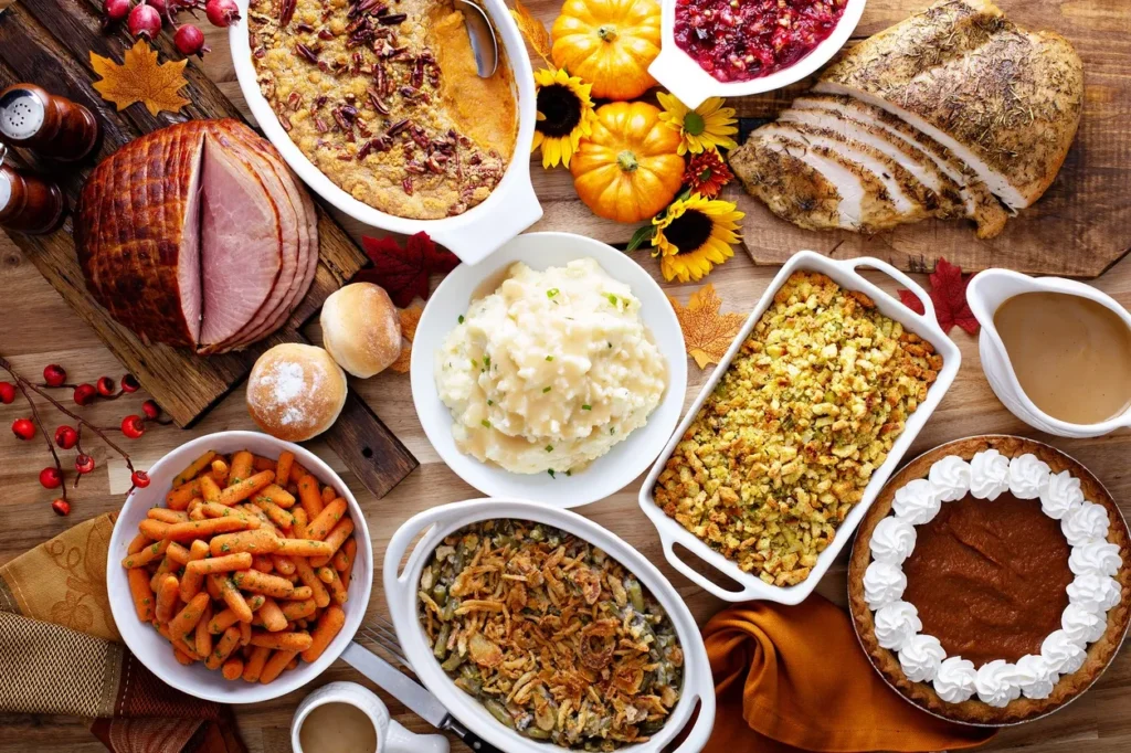 A festive Thanksgiving meal with turkey, mashed potatoes, stuffing, and various side dishes.