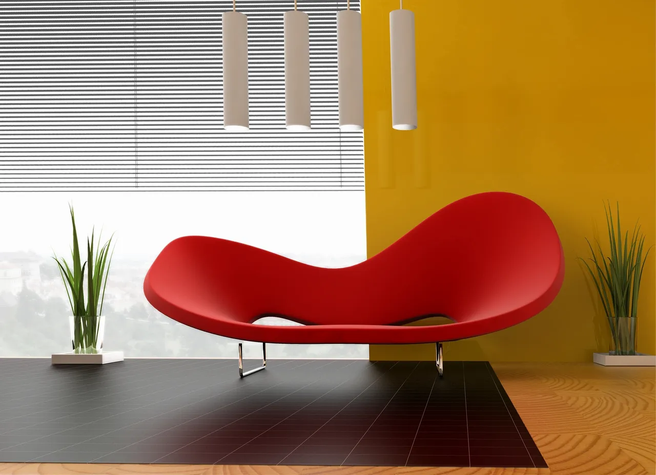 Modern red curved sofa against a vibrant yellow wall in a stylish living room.