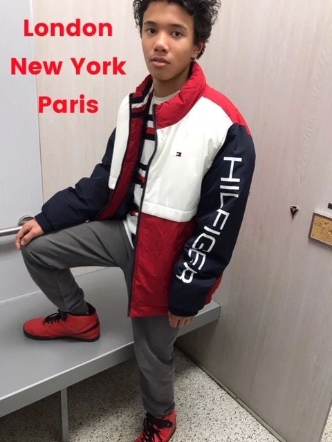 Man posing in stylish Tommy Hilfiger jacket and red shoes.