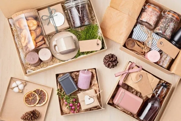 Elegant gift boxes with candles, soaps, and decorative items arranged on a table.