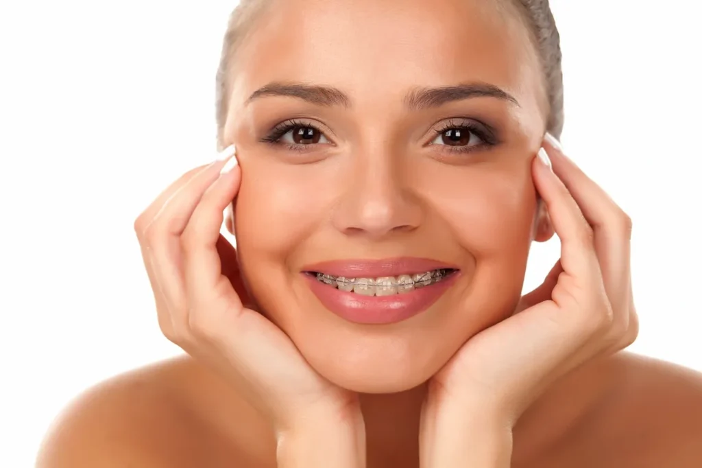 Close-up of a smiling young woman with braces on her teeth.