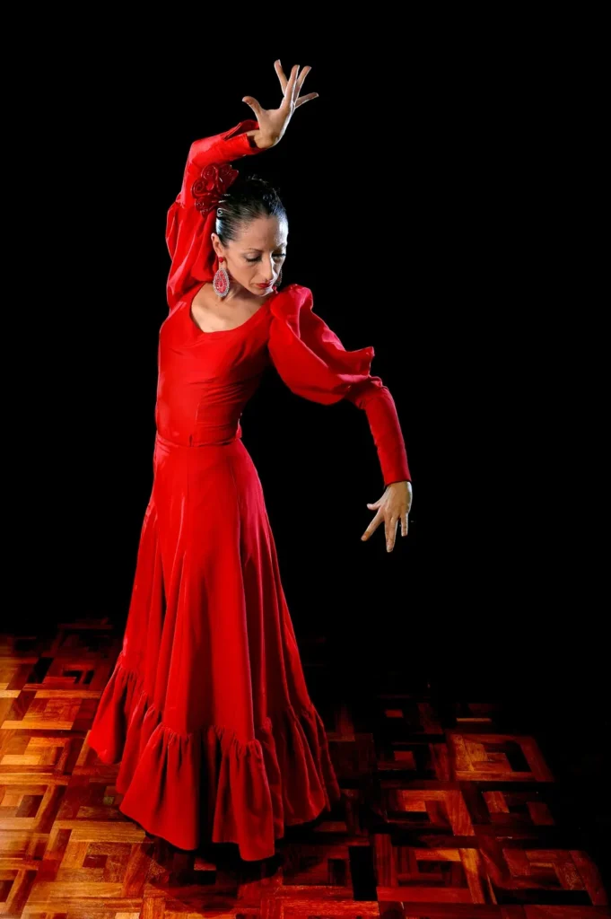 Flamenco dancer in a flowing red dress striking a dramatic pose.