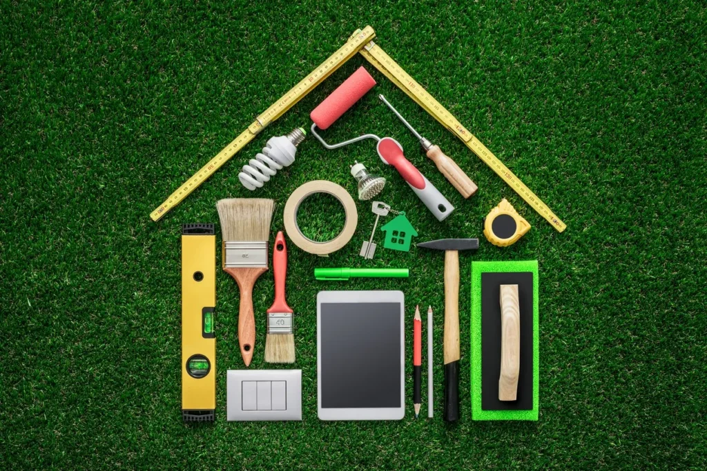 Various painting tools and a digital tablet arranged on grass.