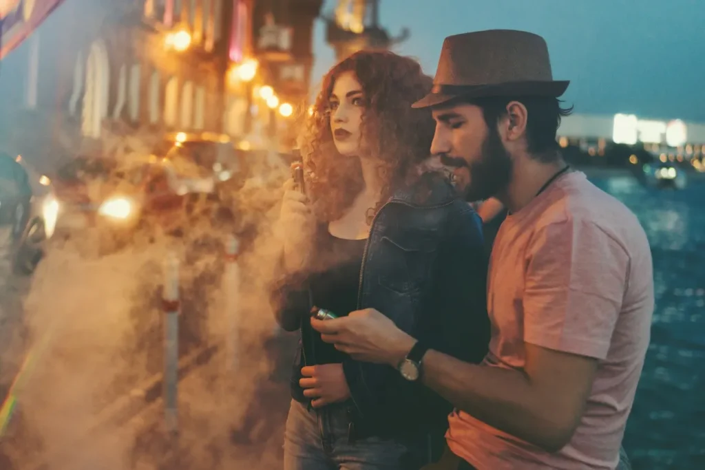 A couple enjoying a smoky atmosphere at night.