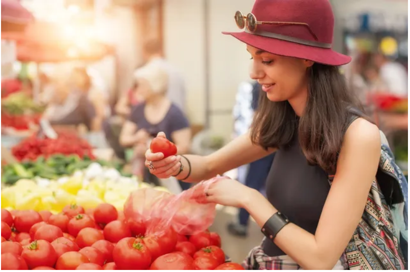 Woman selecting tomatoes at outdoor market